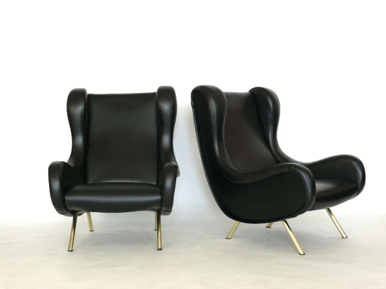 Fantastic pair of sculptural chairs by Marco Zanuso,  known as the Senior Chair. Wonderfully upholstered in black vinyl. Solid brass tapered legs. Beautiful curves and form. Vinyl has signs of wear and use on sides and edges. Additional photos