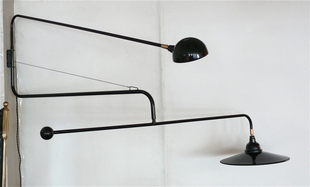 Large scale exquisite black steel double arm articulating wall sconce. Both arms and heads fully pivot and rotate with positional brass adjustments at the shades, the second arm with weighted ball.