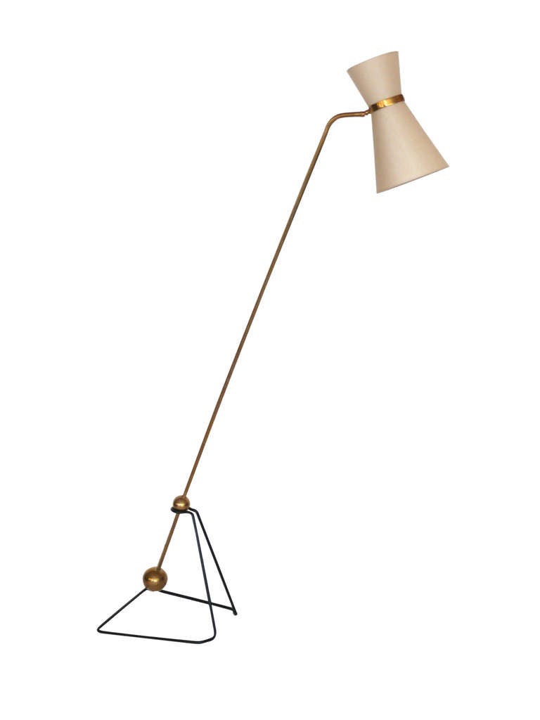 Striking articulating equilibrium floor lamp in the style of Pierre Guariche. Two weighted brass balls rest in a triangular black iron base frame. Custom silk shade pivots up and down. Simple and stunning design. 

Two available, priced
