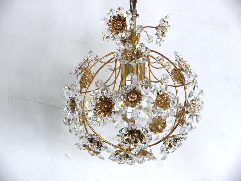 Gorgeous Italian floral crystal pendant with brass frame. Orb shaped pendant with outstretched flowers suspended from brass wires. Small and large crystal flowers with brass center. Newly rewired. Illuminates beautifully.