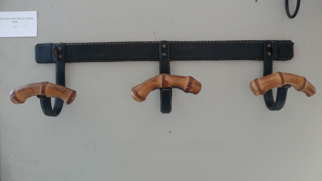 Fantastic original black leather wrapped coat rack with signature contrast stitching by Jacques Adnet. Three arms with curved bamboo hooks. Nice patina to leather.