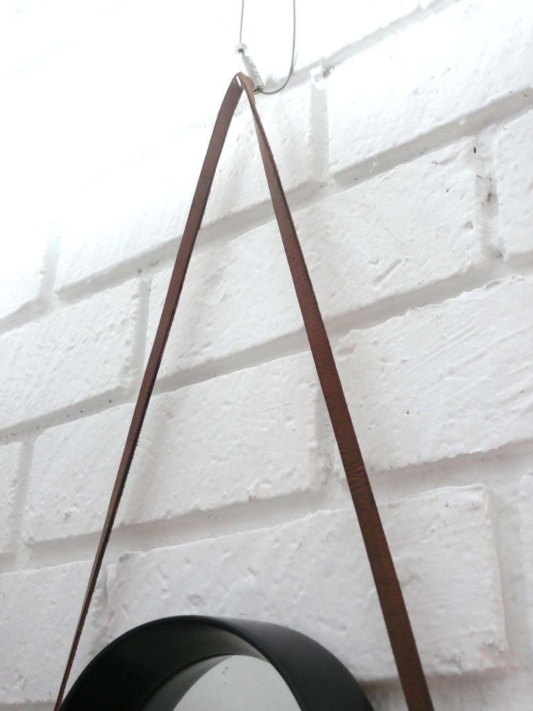 Fantastic triangular shaped wall mirror hanging with new brown leather strap detailing. Wood has been newly refinished in dark ebony stain. Nice curved details in wood. Unique style and design. Mirror height 25.75