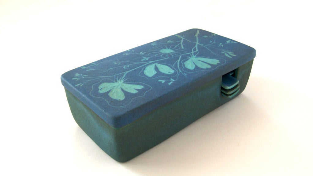 Unique and beautiful blue pottery cigarette box by Raymor. Lid opens to 2 compartments - one to hold cigarettes and the other holding 3 stackable ashtrays. Intricate light blue floral design painted on surfaces. Signed Raymor Italy on underside.