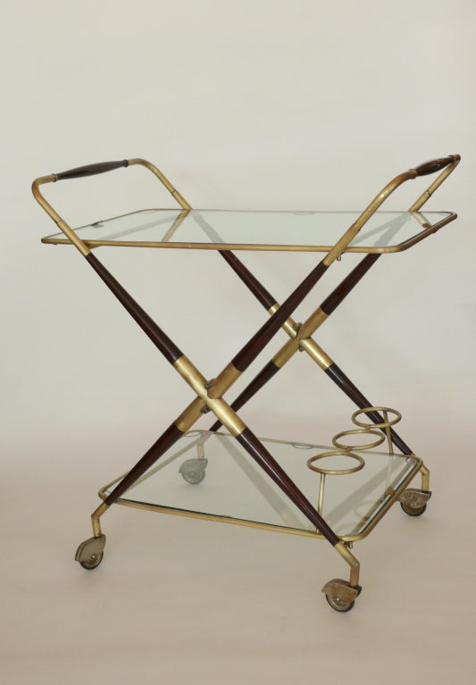 Sleek Italian rolling bar cart with two glass shelves, 3 bottle holder on bottom, and stunning wood and brass frame. Wood has new dark french polish finish. Brass has great patina and age.