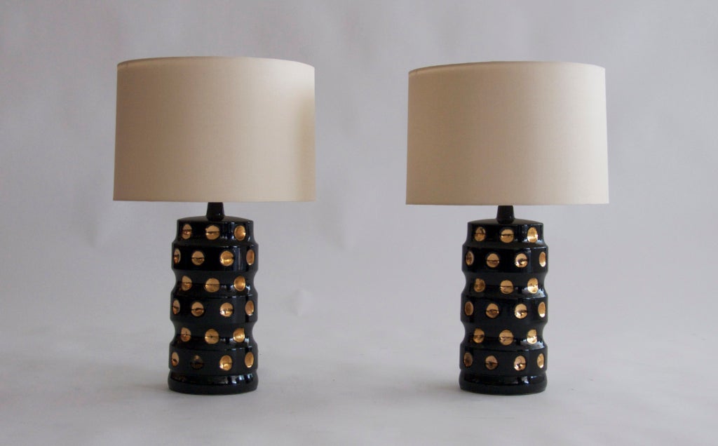 Striking pair of oval shaped black ceramic table lamps rows of convex circles painted a shimmering gold. New silk shade and professionally rewired.<br />
<br />
<br />
Shade is 9.5