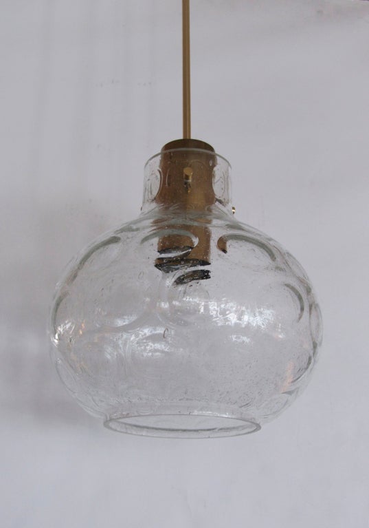 Petite Austrian glass globe pendant with bulbous clear glass with textured circles in surface. Glass suspended and floats from 4 brass pegs and fixture. Newly re-wired.