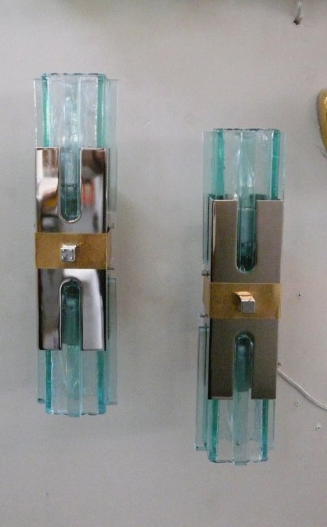 Incredible pair of Italian sconces with thick green glass columns suspended from polished chrome and brass center fixture. Large in scale and beautiful detail. Newly re-wired. One pair and a single sconce available.