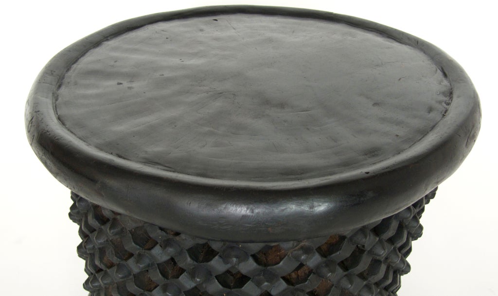 Beautiful African stool carved from one large piece of Teum wood. Intricate rosette design adorns the hollow piece with thick and flat surface. Perfect as small side table, coffee table or stool.