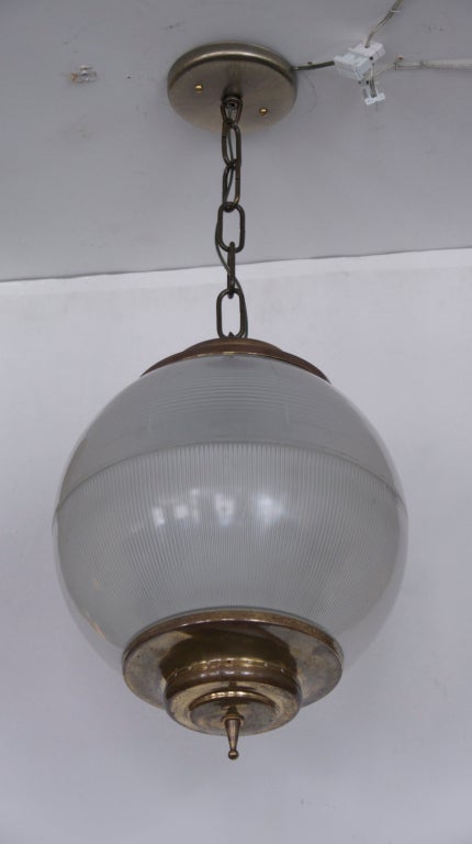 Azucena globe pendant with beautiful perforated brass hardware . Globe is beautiful milky glass with vertical ribbing on bottom half and horizontal ribbing on top half. Large in scale newly rewired.