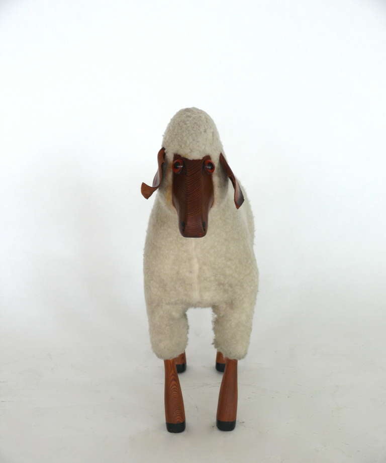 Decorative life size sheep with wooden feet and face. Glass eyes and brown leather ears.  Body made with original creamy white wool. Piece is consistent with age.  In the style of the rare and collectible Francois- Xavier Lalanne sheep.
