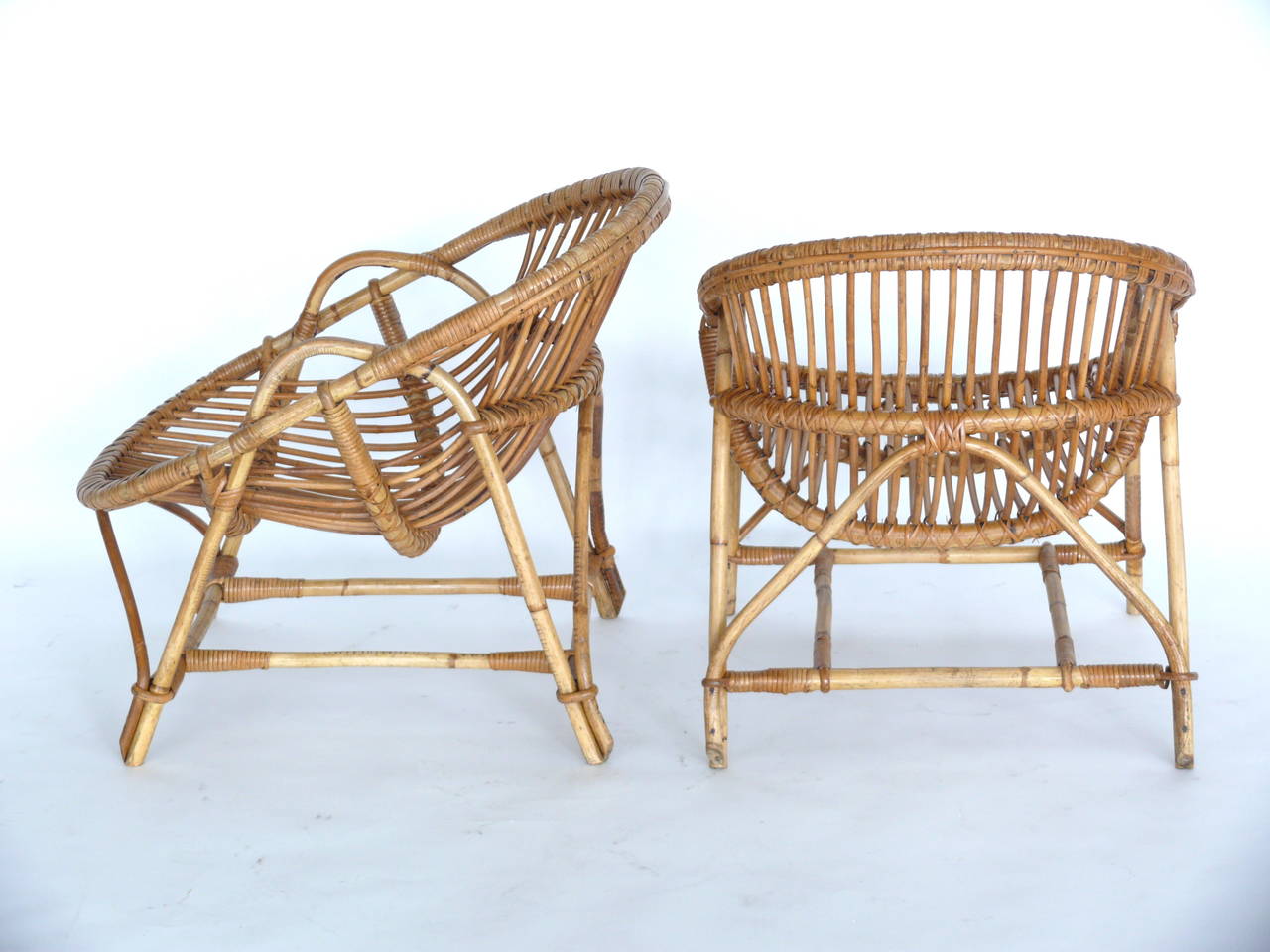 Sculptural pair of Rattan Chairs made in France. Bamboo frame with rattan seat and detail. Unique shape and low profile. Chairs are in excellent vintage condition