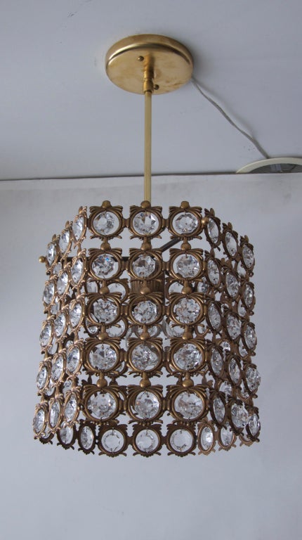 Beautiful Italian chandelier made of ornate brass circles with hanging faceted crystals in a hexagon shape. Three smaller matching pendants also available. Priced individually.