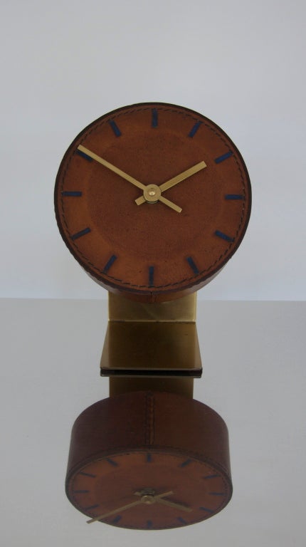 Incredible leather and brass clock by Carl Aubock.  Unique cantilevered design and leather wrapped clock face.  Beautiful stitching on the leather and embossed and painted marks for each hour.  Gorgeous and reminiscent of Jacques Adnet.