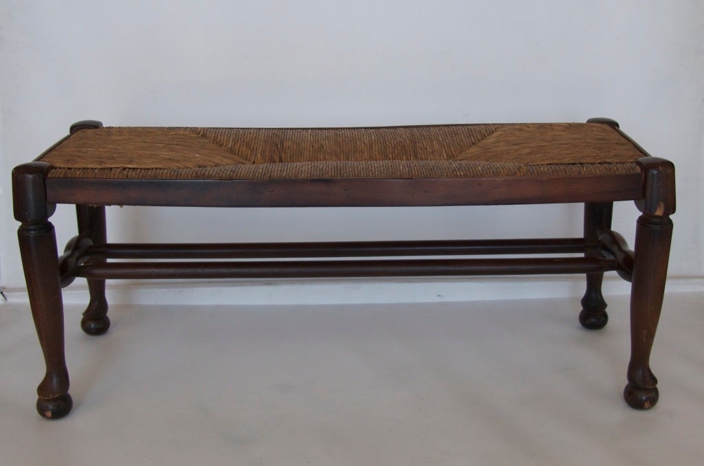 Petite French bench with woven rush seat.  Beautiful shape and thick rush seat is in good condition.