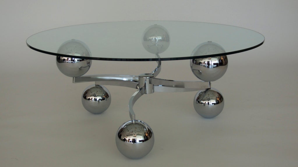 French chrome coffee table with floating glass top.  Base is made of six chrome globes orbiting in two tiers from a cylindrical center piece.  A fantastic statement table.
