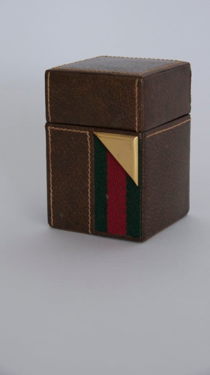 Fantastic leather lighter by Gucci.  Opposite color stitching, fabric band, and brass corner detail.  Stamped in gold 