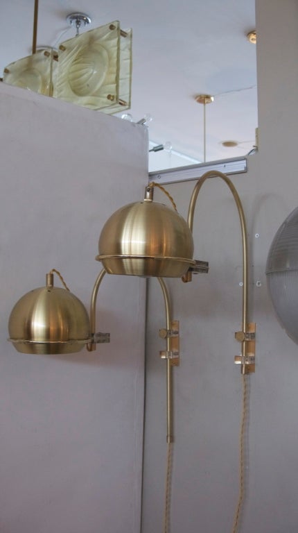 Absolutely fantastic pair of Italian brushed brass arc sconces.  Fully articulating light, adjustable height, and unique lucite detail throughout the fixture.  Professionally rewired and priced as a pair.