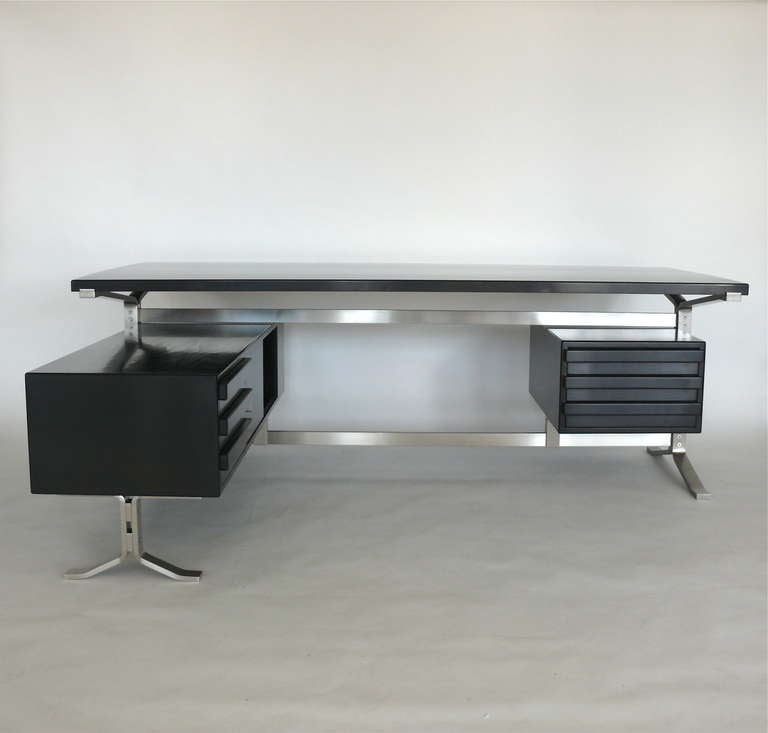 Handsome executive desk by Gianni Moscatelli for Forma Nova. Newly refinished in a dark ebony stain with polished finish. Desk surface rests on flat chromed steel legs with floating drawers on either side. Large work space and extremely impressive!