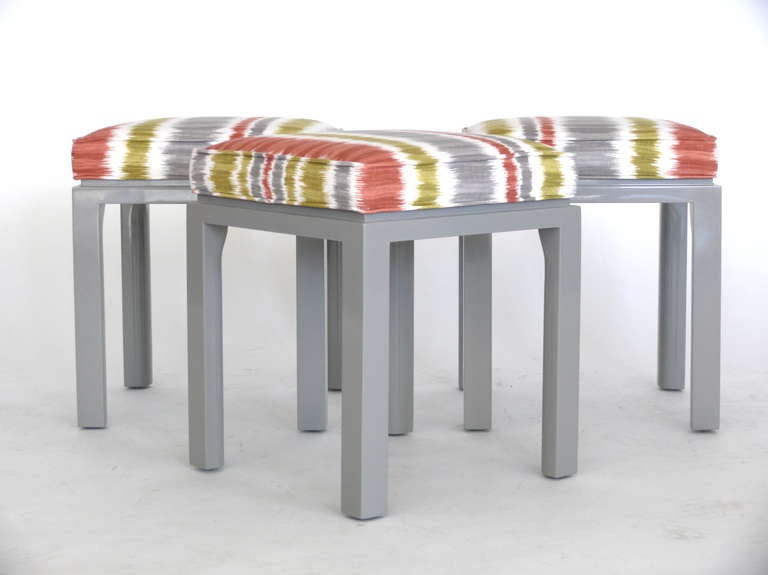 Wonderful set of three square stools by Harvey Probber. Newly refinished in light grey lacquer and new upholstered cushions with vibrant ikat pattern. Great size and function! Three available and sold individually. Label on underside.