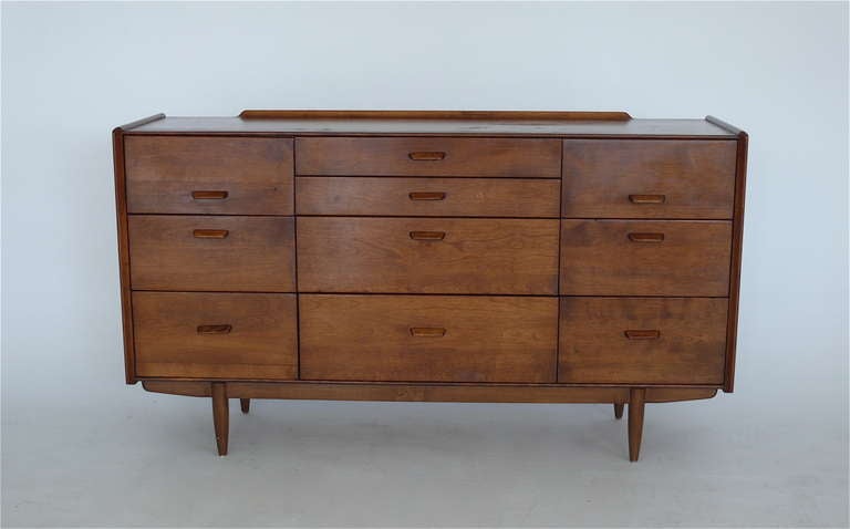 Beautiful wood credenza designed by Russel Wright for Conant Ball. Great storage, with ten pull out drawers of varying size. Nice original condition with great wood grain and character. Maker's stamp on interior drawer.