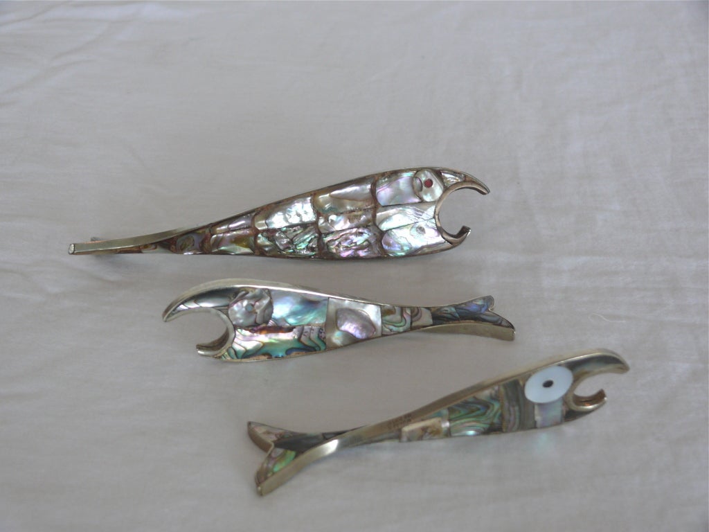 Vintage bottle openers in the shape of fish, made of alpaca silver with pieces of mother of pear fully covering service. Nice twist in tail gives great dimensions and allows it to sit upright. Beautiful pieces of art and great gifts! Stamped 