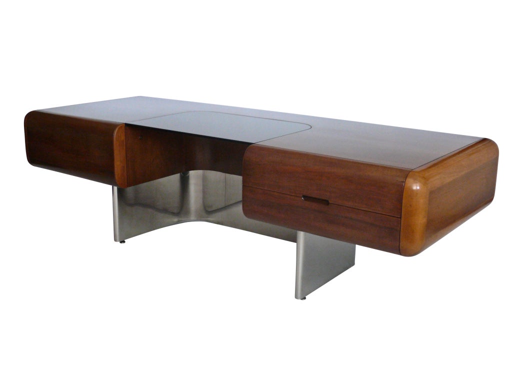 Incredible French hand rubbed walnut veneer desk surface with rounded corners floats on curved stainless steel frame. Solar bronze glass work surface. Original finish and in great vintage condition. Rare and unique piece. One of approximately 30