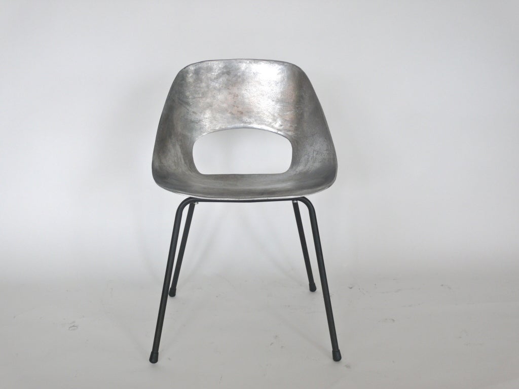 Incredible cast aluminum chair by Pierre Guariche. Sculpted seat sits on sleek 4 leg black metal base. Set of 4 available at a package price. Perfect single statement chair.