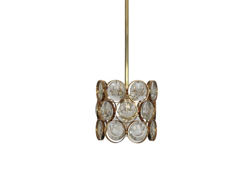 Petite brass and glass pendant by Palwa. Scalloped glass pieces enclosed in brass rings suspended from a brass canopy. Excellent vintage condition. Theree pendants available. Priced individually.