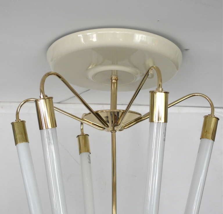 Unique and impressive Italian brass tube chandelier. White painted metal canopy and brass rod support six fluorescent tube shaped bulbs with beautiful curved brass hardware. Illuminates with immense light and presence! Newly rewired.