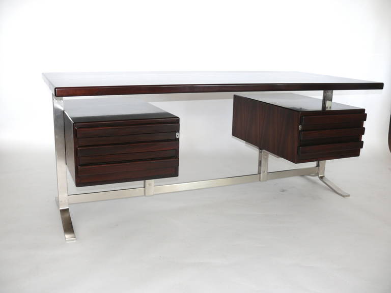 Handsome executive desk by Gianni Moscatelli for Forma Nova. Newly refinished in a dark mahogany stain with polished finish. Desk surface rests on newly plated brushed nickel legs with floating drawers on either side. Great large surface space and
