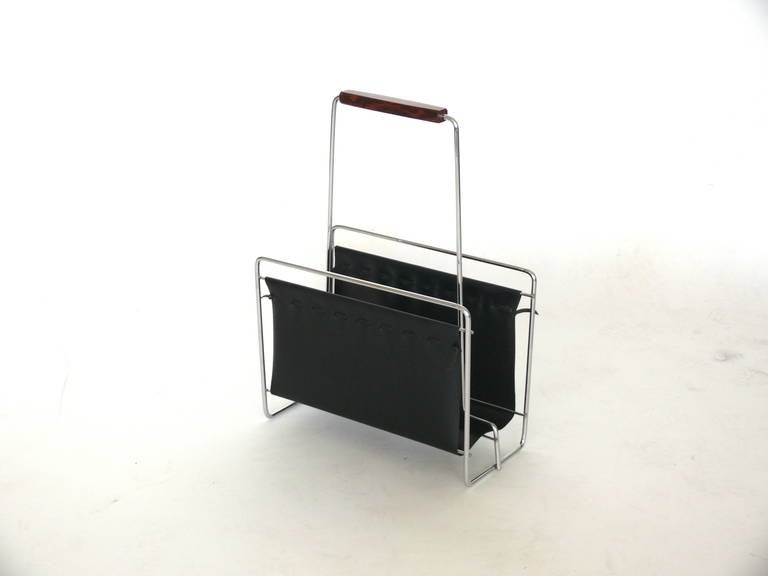 Modern magazine rack with tubular chrome frame and leather sleeves. Large scale with ample room for books or magazines. Wood detail on handle. Excellent vintage condition.
