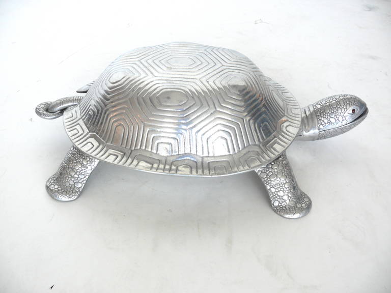 Intricate cast aluminum turtle by Arthur Court. Turtle's shell opens up to provide two different serving platters along with a soup ladle. Turtle head features ruby eyes. Perfect serving dish.