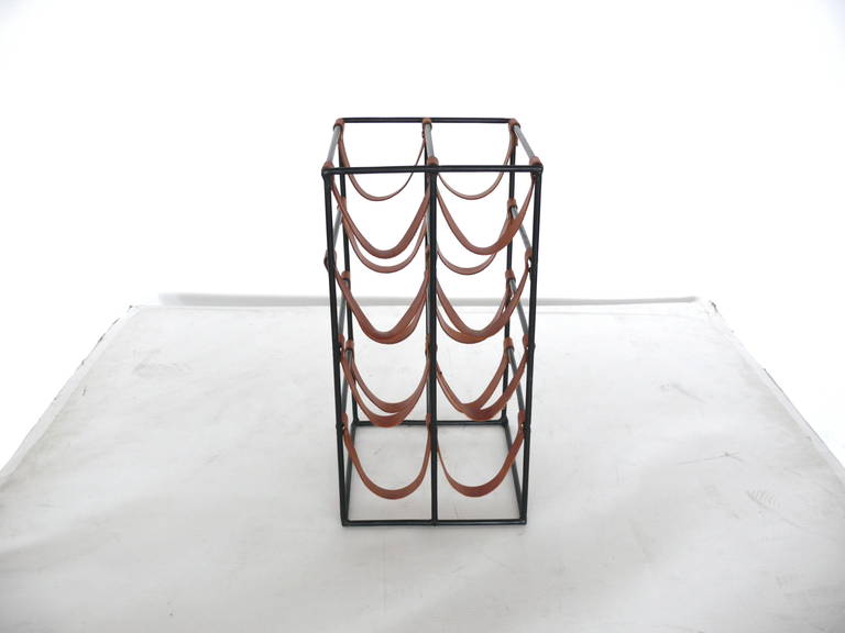 Vintage wine rack by Arthur Umanoff made of black iron and saddle brown leather. Holds 8 wine bottles. Great condition. Similar sized rack with different leather also available.