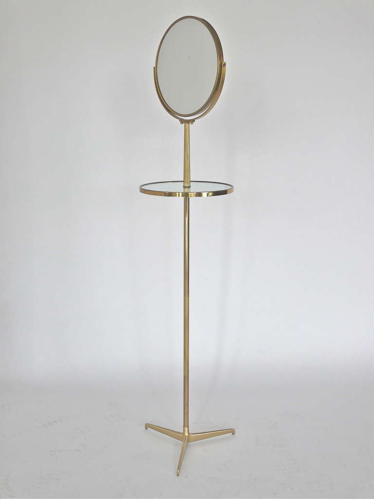 Beautiful vintage freestanding brass vanity mirror with table. Double sided mirror tilts, with one side magnified. Rests on tall elegant brass stem and tripod base. Unique and chic accessory with great function and design!