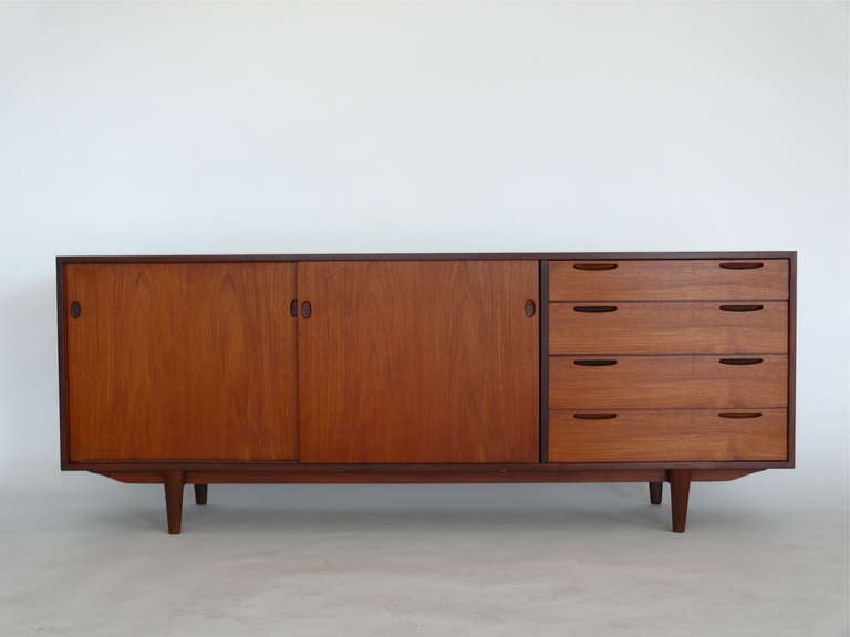 Fantastic Danish teak sideboard or credenza manufactured by Selig.  Four drawers and two sliding doors allow for great storage. Airy design with simple tapered legs.  Great piece in entry way, as a console, in living room or bedroom. Original wood