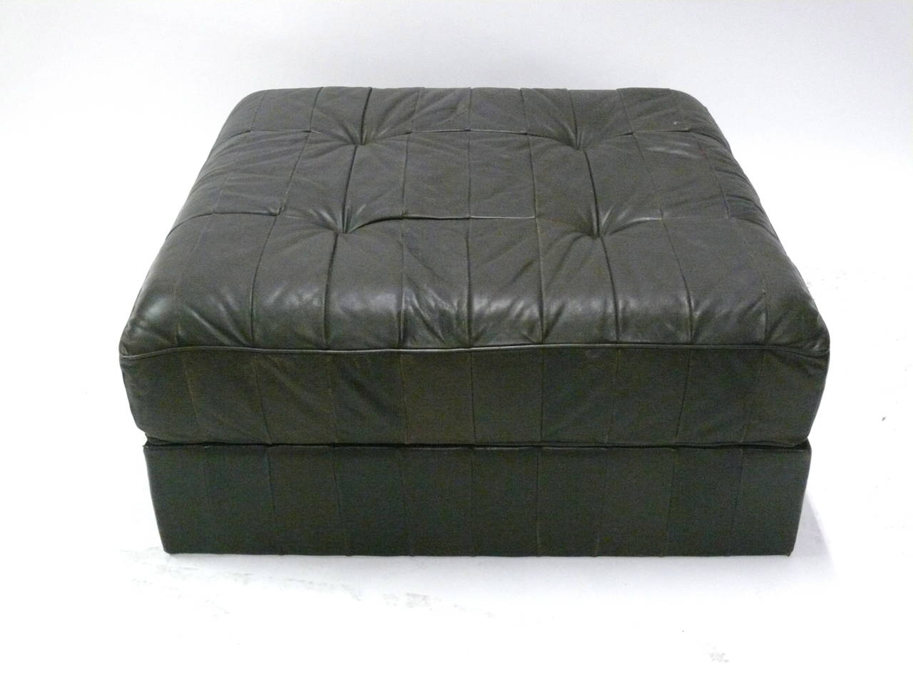 Massive patchwork ottoman by De Sede. Original dark brown and black leather with nice patina and coloring. Good original condition with some minor signs of wear and tear.