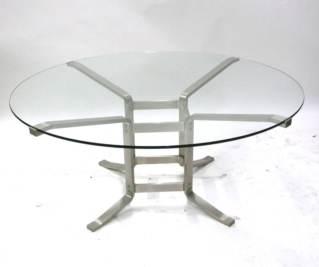 One of a kind Italian table constructed of solid stainless steel. Table features a round glass top that fits securely within the four steel arms branching out from its base. Incredibly heavy construction and beautiful design. Perfect for the foyer