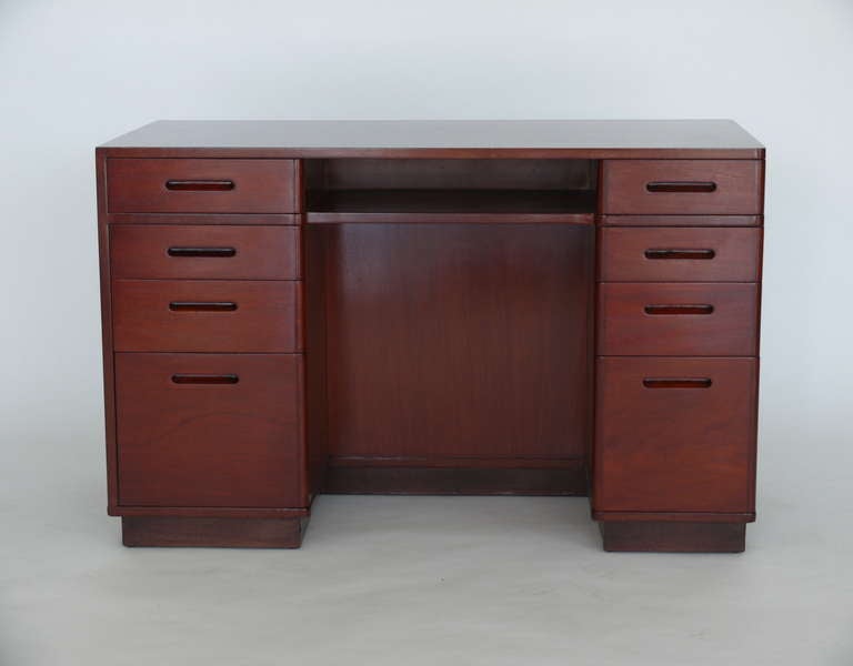 Beautiful mahogany writing desk by Edward Wormley for Dunbar. Perfect scale with eight pull out drawers and center shelf. Back of desk features a tri-level bookcase. Base has a leather wrapped pedestal and piece has been newly refinished.  Stunning
