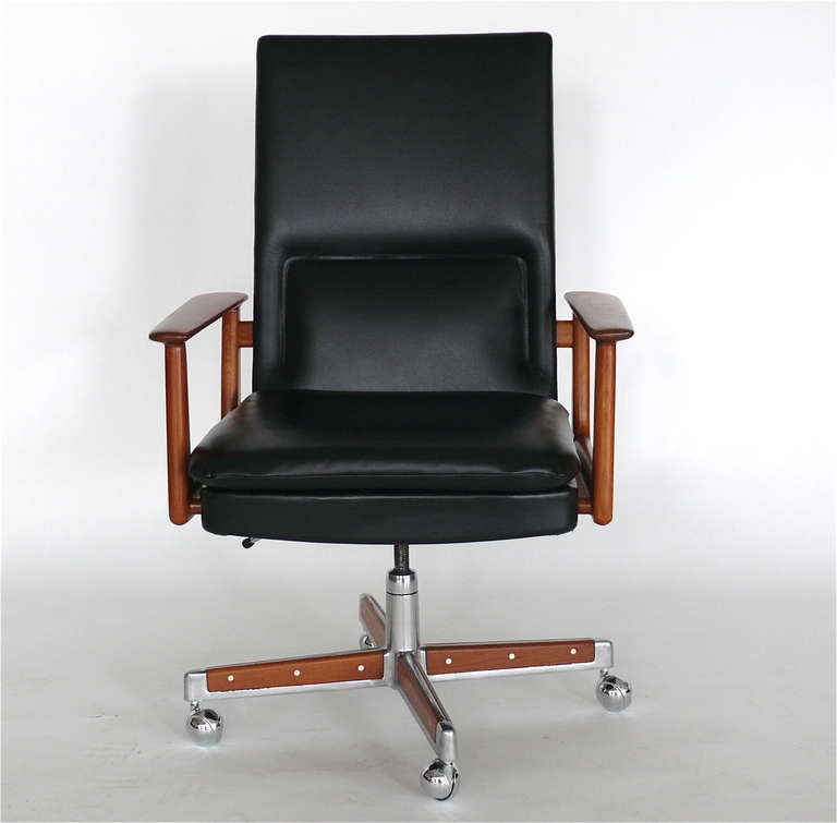 Handsome high back desk chair designed by Arne Vodder.  Newly dyed black leather with original teak armrests. Chair rests on an aluminum base with five new casters. Swivels and is height adjustable. Perfect for any office!
