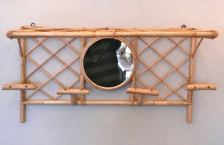 French bamboo wall coat rack with shelf and circular mirror. Bamboo has criss cross design creating a beautiful pattern. Four single bamboo hooks and top shelf make it perfect for an entry way.  