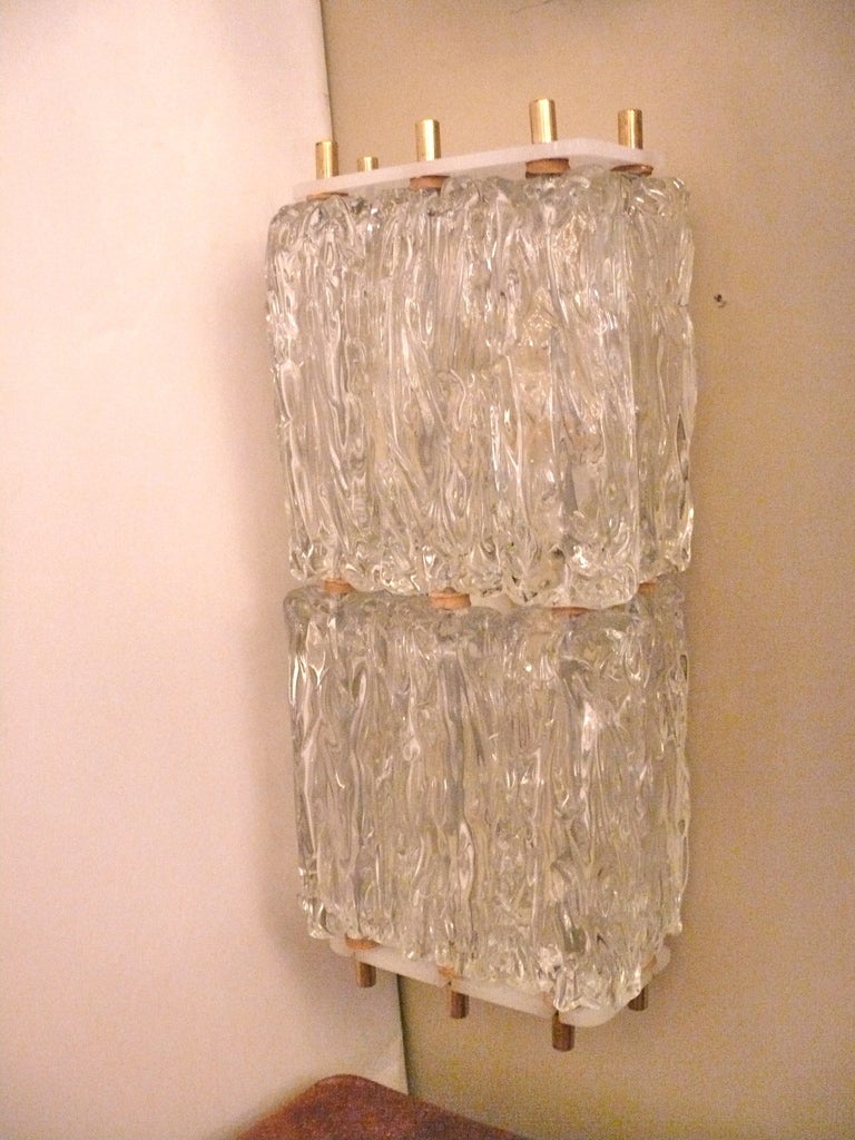 Pair of large scale Kalmar glass sconces.  Two tiers of textured glass. Brass hardware and professionally rewired.