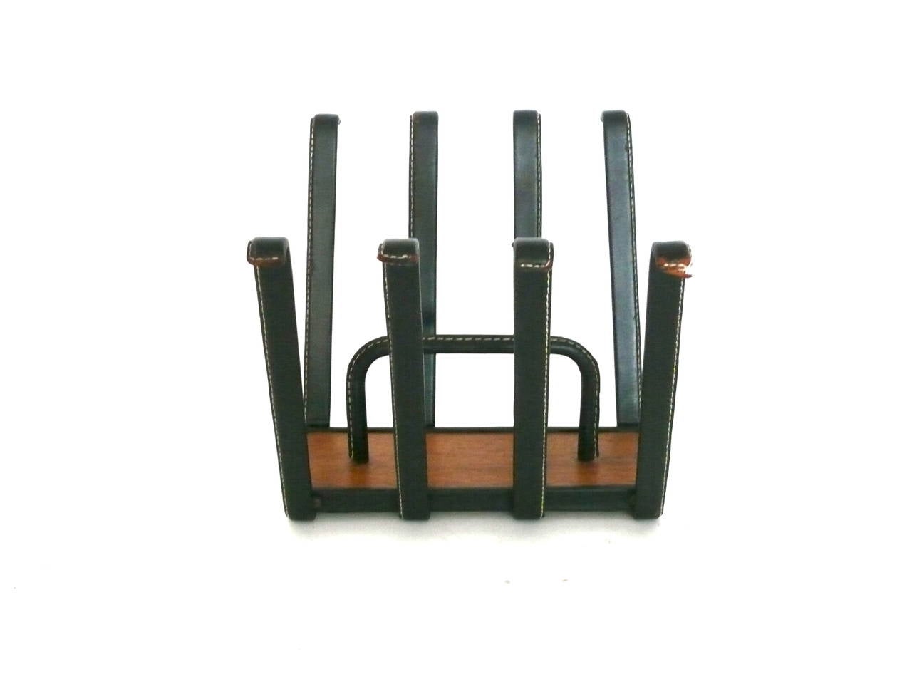 Exquisite magazine rack by Jacques Adnet. Black leather with contrast stitching, with a wood base and brass hardware. Stamped, Made in France, on bottom of rack. Excellent vintage condition.