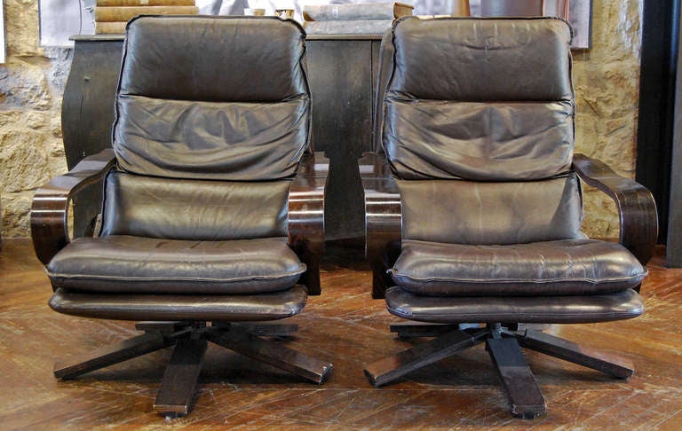 pair of leather and wood chairs with swivel base