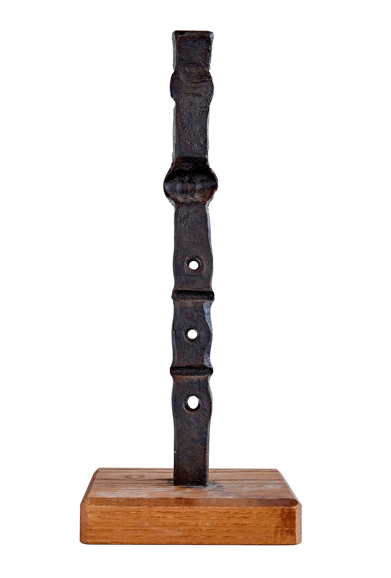 A tall, square section rod of steel, hammered by hot forging into a totemic sculpture of not inconsiderable presence and power. Forging steel is an intensely physical process that recalls the ancient origins of art in tool-making. Mounted on a