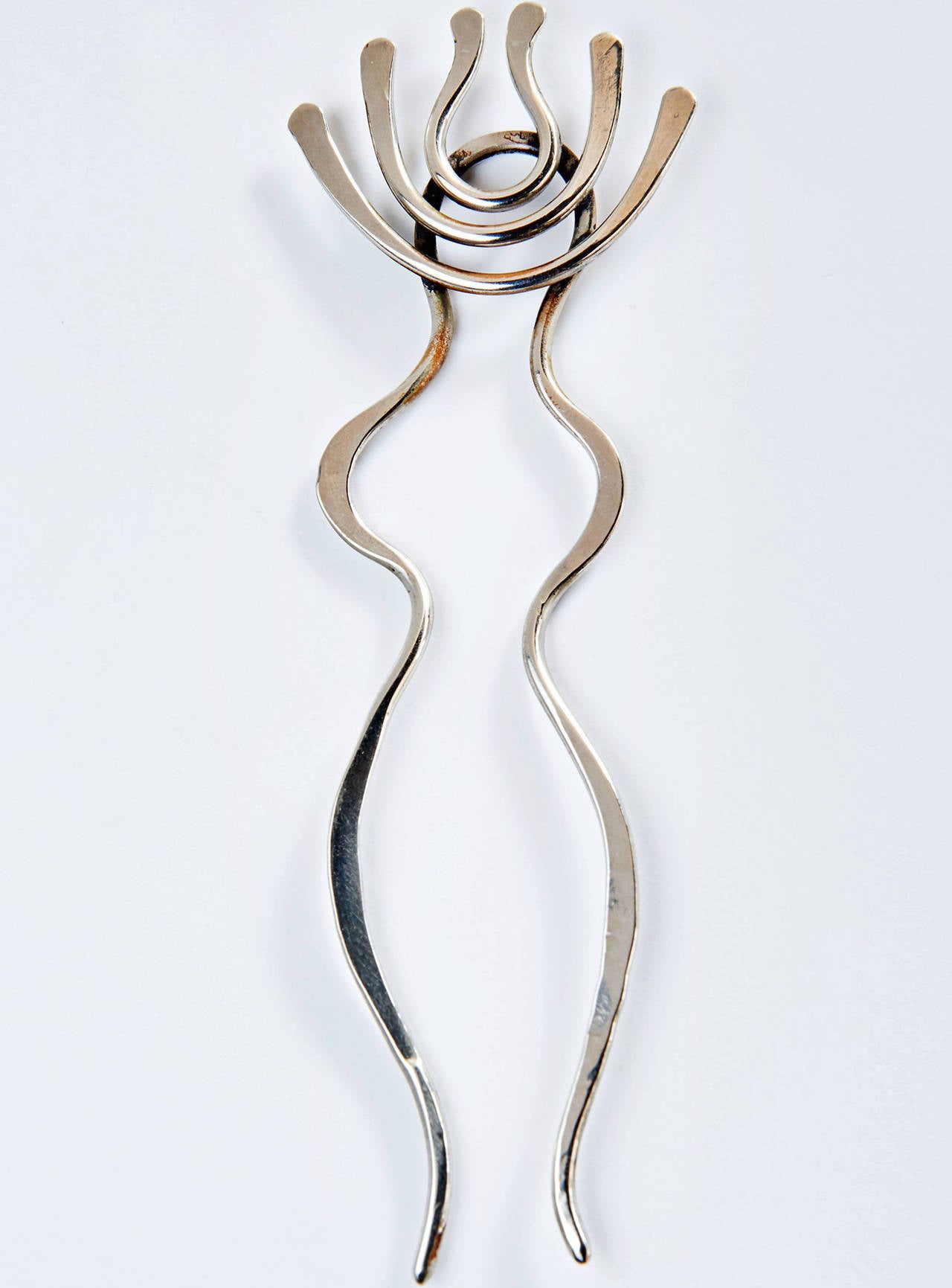 This silver hair pin also happens to be a beautiful abstract sculpture which hints at being a female figure. When not in use atop your head, it can be displayed on its bespoke plinth made of solid Makassar ebony (possibly the rarest, most luxurious