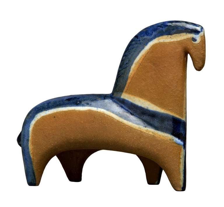 Made of partially glazed stoneware, this affecting little horse is beautifully modeled and detailed. The blue/black glaze sparingly highlights the contours of the horse's form in an almost architectural way. The overall effect is a sophisticated