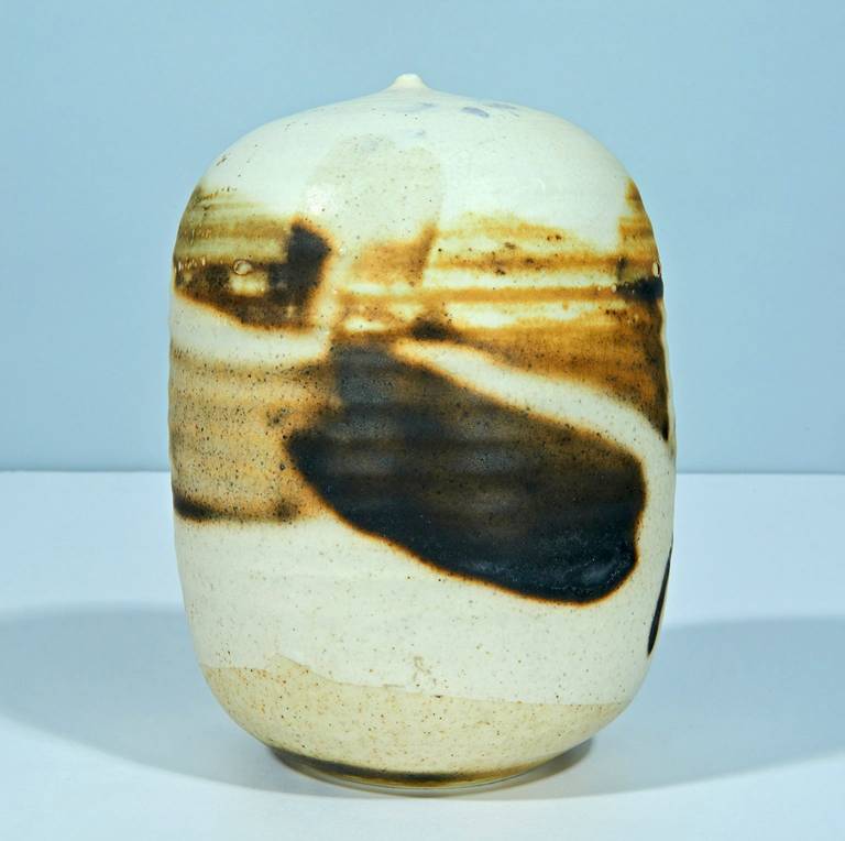 The large, bulbous vase with a tiny mouth was Takaezu's chosen canvas, upon which she painted glazes in dreamy, abstract expressionist gestures. Her trademark rattles, trapped inside the vessel, are easily heard with a firm shake. A