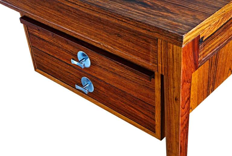 An extraordinarily elegant desk, designed by the greatest of all Scandinavian furniture designers. The Brazil rosewood it is made of is beautifully figured, remarkably unfaded by time and sunlight, and quite vivid. The cases containing the drawers