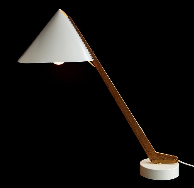 The detail design of this lamp is fantastic: the way the folded aluminum shade is clasped by the teak arm, the way the electrical cord visibly threads through the same arm, the proud brass screws holding everything together. Designed and made by