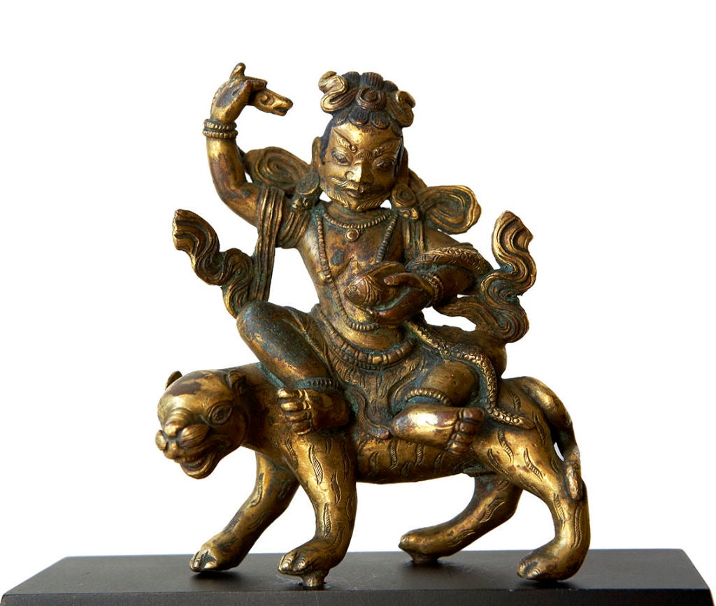 An early and very fine gilt bronze representation of Dombi-Heruka, one of 84 Mahasiddhas (great beings) held in reverence by Tibetan Buddhists. Mahasiddhas were believed to have been actual historical personnages who performed great mystical feats,